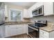 Modern kitchen with white cabinets, granite counters, and stainless steel appliances at 1903 Meadow Ln, Decatur, GA 30032