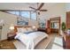 Main bedroom with ceiling fan, large windows, and stylish mid-century modern furniture at 2612 Country Club Se Dr, Conyers, GA 30013
