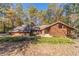 Brick and wood house with large windows, nestled in a wooded setting at 2612 Country Club Se Dr, Conyers, GA 30013