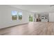 Open-concept living space with hardwood flooring, large windows, and a modern kitchen in the background at 3340 Redwood Ct, Covington, GA 30016
