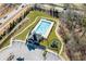 Aerial view of a community pool, playground, parking lot and clubhouse surrounded by green spaces at 3330 Deaton Trl, Buford, GA 30519