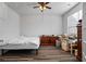 A simple bedroom with a large window, ceiling fan, and wood-look flooring at 3330 Deaton Trl, Buford, GA 30519