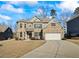 Charming two-story brick home featuring a well-manicured lawn and attached two-car garage at 3330 Deaton Trl, Buford, GA 30519
