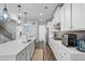 Bright kitchen features white cabinets, stainless steel appliances, a spacious island, and modern pendant lighting at 3330 Deaton Trl, Buford, GA 30519