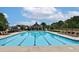 Community swimming pool with crystal-clear water, lounge chairs, and a covered gazebo at 3330 Deaton Trl, Buford, GA 30519