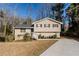 Two-story house with a beige exterior, landscaping, and driveway at 4412 Rustic Wood Dr, Stone Mountain, GA 30083