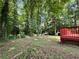 Beautiful backyard view featuring a spacious deck, mature trees, and a playset in the distance at 3945 Peninsula Ct, Lawrenceville, GA 30044
