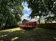 Home's large yard featuring a well maintained lawn, mature trees and a spacious deck in the back at 3945 Peninsula Ct, Lawrenceville, GA 30044