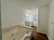 This bathroom offers a soaking tub and a double vanity with wood-look flooring at 3945 Peninsula Ct, Lawrenceville, GA 30044