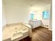 Bathroom boasting a soaking tub, double vanity, and wood flooring at 3945 Peninsula Ct, Lawrenceville, GA 30044