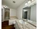 Bathroom featuring granite countertop, a tub, a separate shower, and white walls at 3945 Peninsula Ct, Lawrenceville, GA 30044