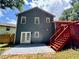 Charming home exterior featuring gray siding, white trim, and a back yard with a red deck and stairs at 3945 Peninsula Ct, Lawrenceville, GA 30044