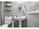 Cozy bathroom features a pedestal sink, toilet, and floating wood shelves at 2418 Brookdale Ne Dr, Atlanta, GA 30345