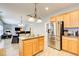 Open kitchen with stainless steel refrigerator, functional island, and seamless flow to living areas at 3258 Kessock Ridge Trl, Snellville, GA 30039