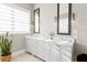 Bright bathroom featuring dual sinks, white cabinets, modern fixtures, and two mirrors on the wall at 6750 Avis Walk, Alpharetta, GA 30005