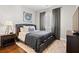 Cozy bedroom featuring hardwood floors, a tufted headboard, a window with dark curtains, and artwork on the wall at 6750 Avis Walk, Alpharetta, GA 30005