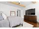 Charming bedroom featuring wooden beams, shiplap walls, hardwood floors, and a dresser with a large-screen TV at 6750 Avis Walk, Alpharetta, GA 30005