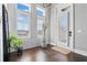 Bright entryway with large windows, plantation shutters, hardwood floors, and a potted plant at 6750 Avis Walk, Alpharetta, GA 30005