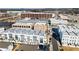 Aerial view of neighborhood with three-story townhomes, modern farmhouse style homes and commercial buildings at 6750 Avis Walk, Alpharetta, GA 30005