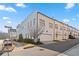 View of row of new construction townhomes with attached garages and painted brick facade at 6750 Avis Walk, Alpharetta, GA 30005