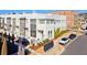 Three-story painted brick townhomes featuring private balconies and manicured landscaping at 6750 Avis Walk, Alpharetta, GA 30005