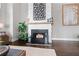 Cozy fireplace with decorative elements and a wooden mantel, complemented by plants and firewood at 6750 Avis Walk, Alpharetta, GA 30005