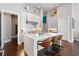 Bright, modern kitchen with white cabinets, white countertops, stainless steel appliances, and bar stool seating at the island at 6750 Avis Walk, Alpharetta, GA 30005