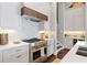 Close up of modern kitchen appliances including range and hood with white cabinets and countertop space at 6750 Avis Walk, Alpharetta, GA 30005