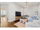 Bright living room with light gray walls and wood floors, white sofa, and a modern coffee table at 6750 Avis Walk, Alpharetta, GA 30005