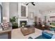 Spacious living room with a fireplace, stylish furniture, and hardwood floors; kitchen visible in background at 6750 Avis Walk, Alpharetta, GA 30005