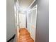 Hallway with gray walls, hardwood floors, and built-in linen closet at 75 Maygold St, Mcdonough, GA 30253