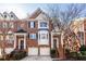 Brick front exterior of a three-story townhome with a two-car garage at 5877 Riverstone Cir # 17, Atlanta, GA 30339