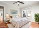 Staged primary bedroom features a bed, rug, and nightstands with lamps, along with multiple windows at 1015 Deckner Sw Ave, Atlanta, GA 30310