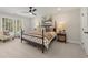 Bright bedroom featuring a four-poster bed, large window, neutral decor, and comfortable seating area at 4517 Twinberry Dr, Powder Springs, GA 30127