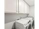 Laundry room with white cabinets above a GE washer and dryer at 3330 Harmony Hill Rd, Kennesaw, GA 30144