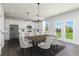 Open-concept kitchen and dining area with white cabinets, stainless steel appliances, and natural light at 313 Chattahoochee Cir, Locust Grove, GA 30248