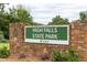 High Falls State Park sign with decorative stone wall, landscaped greenery, and welcoming aesthetic at 313 Chattahoochee Cir, Locust Grove, GA 30248