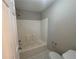 Standard bathroom featuring a shower-tub combo with white tiling, toilet, and light grey walls at 854 Fayetteville Se Rd, Atlanta, GA 30316
