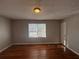 Spacious bedroom with hardwood floors, a large window, and a standard door at 854 Fayetteville Se Rd, Atlanta, GA 30316