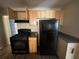 Well-lit kitchen featuring wooden cabinets, black appliances and dark countertops at 854 Fayetteville Se Rd, Atlanta, GA 30316