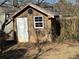 Wooden shed with a white door and window in a grassy backyard setting at 854 Fayetteville Se Rd, Atlanta, GA 30316