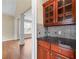 Charming butler's pantry showcasing granite countertops, cherry cabinets, and views into dining and living spaces at 3413 Talking Creek Ct, Conyers, GA 30094