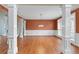 Spacious dining room featuring hardwood floors, columns, wainscoting, and a modern chandelier at 3413 Talking Creek Ct, Conyers, GA 30094