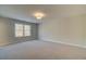 A bright, carpeted bedroom with a window and a ceiling light at 4521 Twinberry Dr, Powder Springs, GA 30127