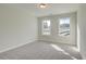 Bright bedroom featuring neutral carpet, two windows, and ample natural light at 4521 Twinberry Dr, Powder Springs, GA 30127