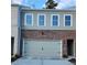 Two-story townhome with brick facade, attached garage, and neutral color scheme at 4521 Twinberry Dr, Powder Springs, GA 30127