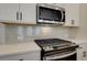 Close up of kitchen showing stainless appliances, tile backsplash, and white quartz counters at 4521 Twinberry Dr, Powder Springs, GA 30127