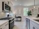 Modern kitchen with white cabinets, herringbone backsplash, and stainless steel appliances at 4521 Twinberry Dr, Powder Springs, GA 30127