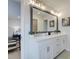 Double vanity bathroom with large mirror and grey tile floor at 4529 Twinberry Dr, Powder Springs, GA 30127