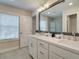 Double vanity bathroom with white cabinets, gray tile, and a large mirror at 4529 Twinberry Dr, Powder Springs, GA 30127